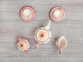 juego de té de porcelana rosa sobre mesa marrón gris foto