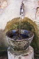 cuenca antigua con agua en la calle en la ciudad de roma foto