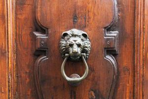 lion head knocker on old wooden door in Florence photo