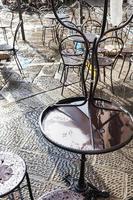 wet tables in street cafe in Florence after rain photo