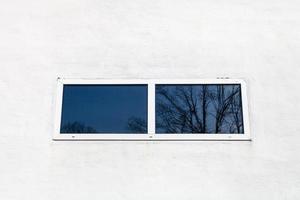 glass window in white painted wall photo