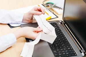 medic examines patient electrocardiogram photo