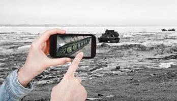 turista tomando una foto del vehículo rastreado en la carretera de hielo