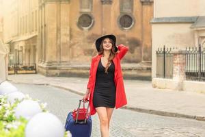 Beautiful young girl walking with blue suitcase. photo