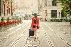 Beautiful young girl walking with blue suitcase. photo
