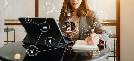 Hands of woman using mobile phone in modern office with laptop and digital tablet computer with VR icon diagram at office photo