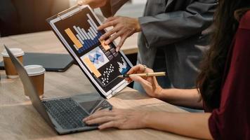 Bussinessman analyzing sales data and economic growth and pointing at business report document with graph chart financial chart marketing, banking and payments at office photo