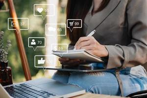 concepto de pantalla de iconos virtuales de redes sociales y marketing. primer plano de una mujer de negocios escribiendo teclado con computadora portátil foto