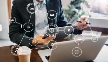 Businessman using mobile phone and laptop computer with business intelligence concept. with VR icon photo
