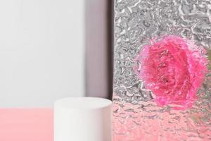 empty geometric podium for product presentation, rose flower behind textured glass. beauty and cosmetic product display. template or mockup. photo