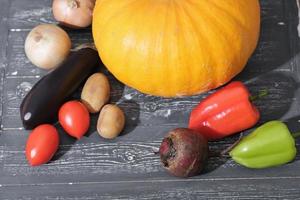 cosecha de otoño verduras de calabaza orgánicas. verduras cultivadas en el jardín o cultivadas en granjas. verduras de cosecha propia. verduras orgánicas frescas en una mesa de madera oscura. concepto de tienda de comestibles. foto