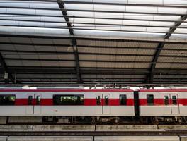 The electric train stops to pick up passengers at a suburban station. photo