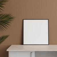 Minimalist front view square black photo or poster frame mockup leaning against wall on table with plant. 3d rendering.