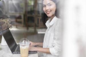 A young woman working with laptop computer in cafe photo