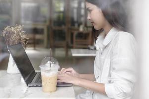 A young woman working with laptop computer in cafe photo