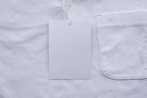 Blank white clothes tag label on new shirt photo