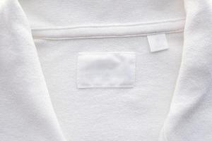 Blank white clothes label on new shirt background photo