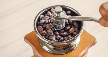 molinillo de café manual vintage con granos de café tostados foto