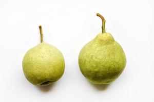 Two green ripe pears on a white background in autumn. Two fruits of a green pear in close-up.