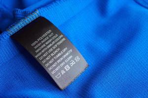 cuidado de la ropa negra instrucciones de lavado etiqueta de la ropa en la camiseta deportiva de poliéster jersey azul foto