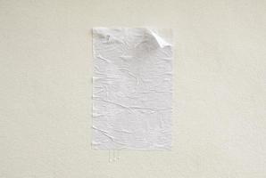 Blank white crumpled and creased adhesive street poster mockup on concrete wall background photo