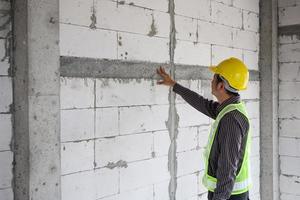 trabajador de ingeniero de construcción de hombre de negocios asiático en el sitio de construcción de viviendas foto