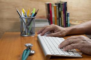 Person with hand on keyboard at an office desk photo