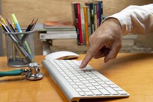 Person with hand on keyboard at an office desk photo