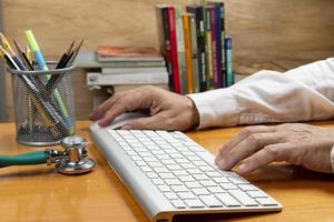 Person with hand on keyboard at an office desk photo