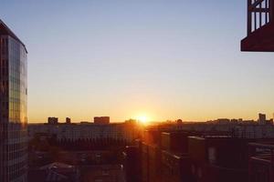 the sun rises above the skyline illuminating the houses and streets of the sleeping city photo