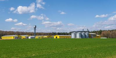 vista panorámica sobre el elevador de granero de silos agrícolas en la planta de fabricación de procesamiento agrícola para el procesamiento de secado, limpieza y almacenamiento de productos agrícolas, harina, cereales y granos. foto