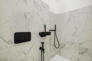 toilet and detail of a corner shower cabin with wall mount shower attachment photo