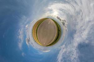 pequeño planeta en cielo azul nublado con hermosas nubes con transformación de panorama esférico de 360 grados. vista aérea abstracta esférica. curvatura del espacio. foto