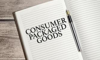 CPG - Consumer Packaged Goods concept words on notepad and calculator and wooden background photo