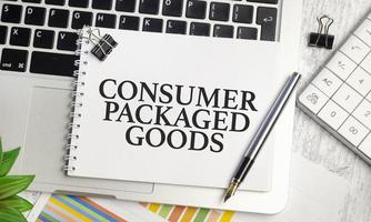 CPG - Consumer Packaged Goods text and notepad with pen, charts and calculator photo
