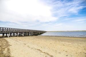 Wooden pier by the beach and ocean in the summer photo