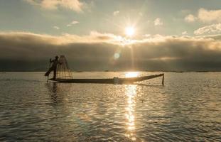 The silhouette of Intha fisherman of Inle lake, Myanmar. The Intha are the only people in the world to fish using one leg. photo