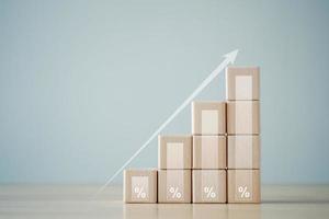 Interest rate finance and mortgage rates concept. percentage sign on stack of wooden blocks and arrow up. financial growth, interest rate increase, inflation, sale price and tax rise concept. photo