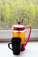 tea kettle and mug on home windowsill photo