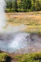 small geyser in Haukadalur valley in Iceland photo