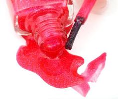 bottle with spilled red nail polish close up photo