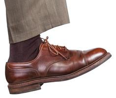 male right leg in brown shoe takes a step photo