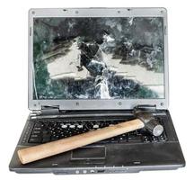 direct view of old broken laptop with hammer photo