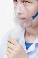 girl breathes with face mask of jet nebulizer photo