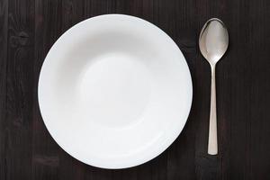 vista superior plato hondo con cuchara en mesa marrón oscuro foto