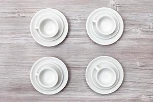 top view of four cups and saucers on gray table photo