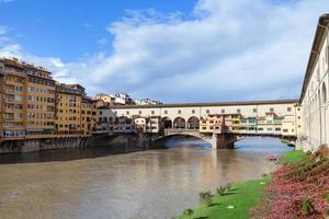 ponte vecchio sobre el río arno en un día soleado de otoño foto