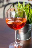 glass of Spritz cocktail with ice on table photo