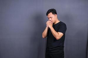 sad man with hands on face in sadness, isolated on gray background, copyspace photo