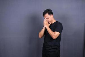 sad man with hands on face in sadness, isolated on gray background, copyspace photo